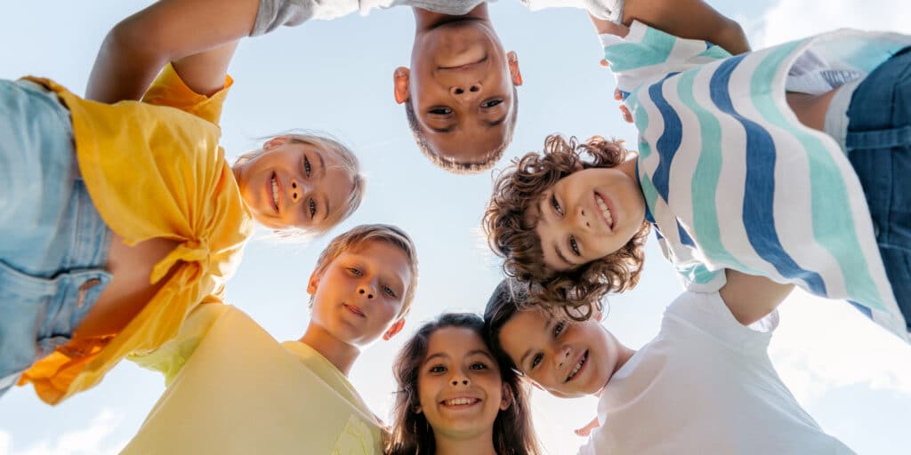 un cerchio di bambini sorridenti che si abbracciano